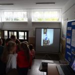 Dzieci oglądają zdjęcia z obchodów 50-lecia Szkoły Podstawowej nr 4 w Grajewie