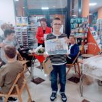 Uczeń stoi z nagrodą, a w tle współorganizatorki Nocy Księgarń