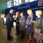 Dyrektor szkoły wręcza nagrody z okazji Dnia Edukacji Narodowej nauczycielom