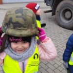 Dziewczynka zakłada hełm wojskowy