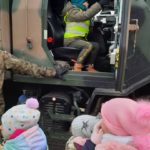 Dziecko siedzi w kabinie samochodu wojskowego