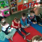 Przedszkolaki siedzą na podłodze