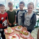 Dzieci stoją przy stoliku ze zdrowymi kanapkami