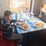 Chłopcy jedzą pizzę