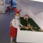 Dziewczynka układa z zabawek drewnianych zagrodę gospodarską