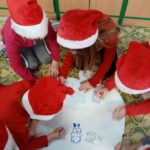 Dzieci rysują na kartce na podłodze