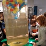 Dzieci ogładają piłeczki w wirówce wypełnionej wodą