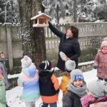 Dzieci dokarmiają ptaki przy szkole