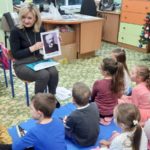 Nauczycielka pokazuje przedszkolakom zdjecie Piotra Czajkowskiego