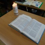 Na stole Pismo święte i paląca się świeca