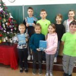 Dzieci stoją przy chince i trzymają Pismo święte