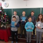 Dzieci stoją przy chince i trzymają Pismo święte
