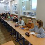 Uczniowie siedzą przy stolikach