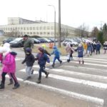Dzieci przechodzą po pasach przez ulicę