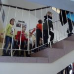 Przedszkolaki idą klatką schodową schodową na górę