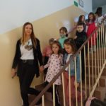Przedszkolaki z nauczycielką schodzą klatką schodową