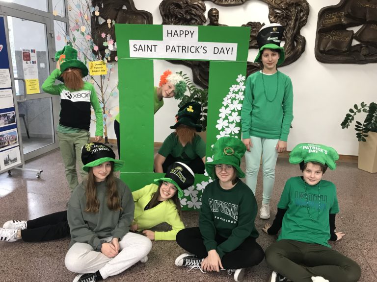 Dzieci ubrane na zielono pozdrawiają i życzą miłego Dnia Świętego Patryka