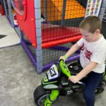 Chłopczyk w sali zabaw jeździ na motorze