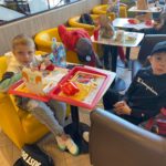 Chłopcy spożywają posiłek w McDonaldzie