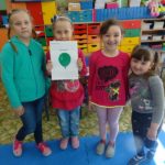 Dziewczynki trzymają obrazek z zielonym balonikiem