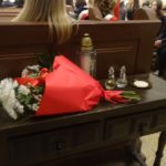 Wiązanka kwiatów leży na stoliku w kościele