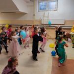 Przedszkolaki w strojach bajkowych tańczą