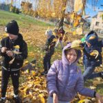 Dzieci podrzucają do góry jesienne liście