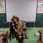 Trzech uczniów trzyma dużego pluszowego lwa