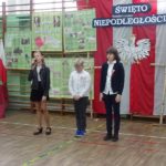 Narodowe Święto Niepodległości w SP 4 - troje uczniów, w tym jedna uczennica śpiewa