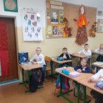 Narodowe Święto Niepodległości w SP 4 - uczniowie w siedzą w klasie w strojach galowych z przypiętymi kotylionami