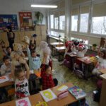 Dzieci w klasie trzymają w górze swoje misie