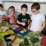 Dzieci w pracowni kulinarnej przygotowują zdrowe kanapki