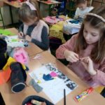 Dzieci projektują na kartce ubrania