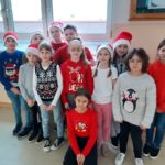 Mikołajki w SP 4 - dzieci ubrane na czerwono i w czapkach Mikołaja