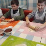 Warsztaty kulinarne klasy III b w pizzerii Da Grasso - chłopcy wałkują ciasto