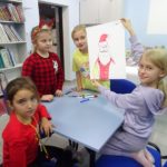 Mikołajki w bibliotece - cztery dziewczynki pokazują swój rysunek Mikołaja
