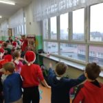 Dzieci ubrane na czerwono tańczą na korytarzu