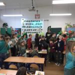 Uczniowie ubrani na zielono w klasie i z transparentem
